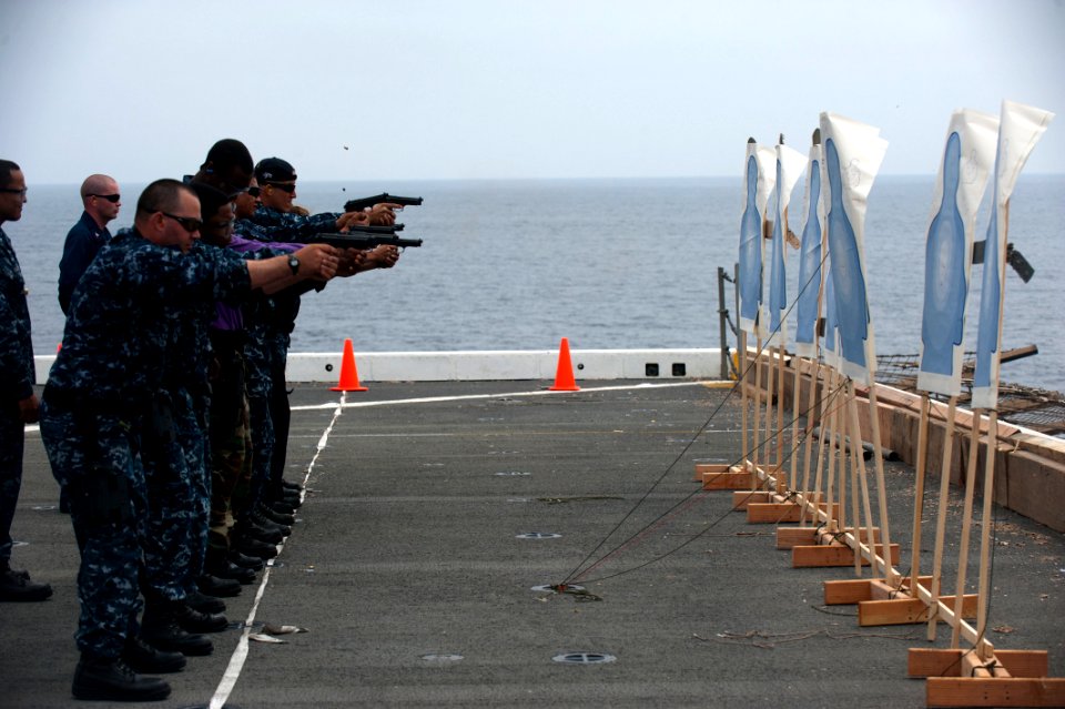 US Navy 110817-N-PB383-016 Sailors take aim at their targets during 9mm pistol qualifications aboard the San Antonio-class amphibious transport doc