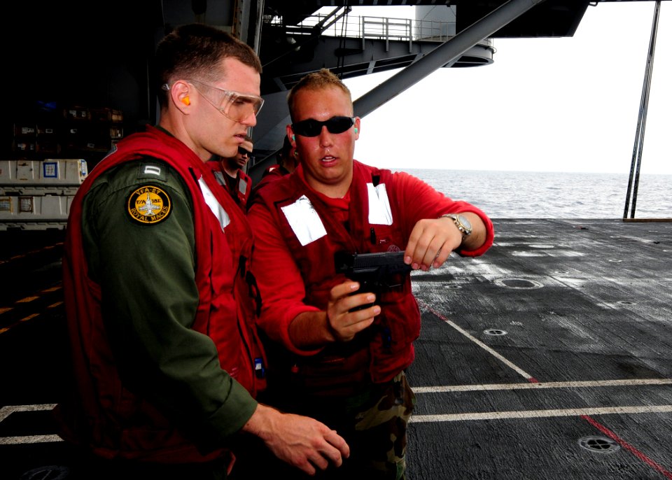 US Navy 110812-N-JO245-027 Airman Andrew Grooters, right, shows Lt. Charles Matykiewicz, the de-cocking feature on an M11 9mm service pistol