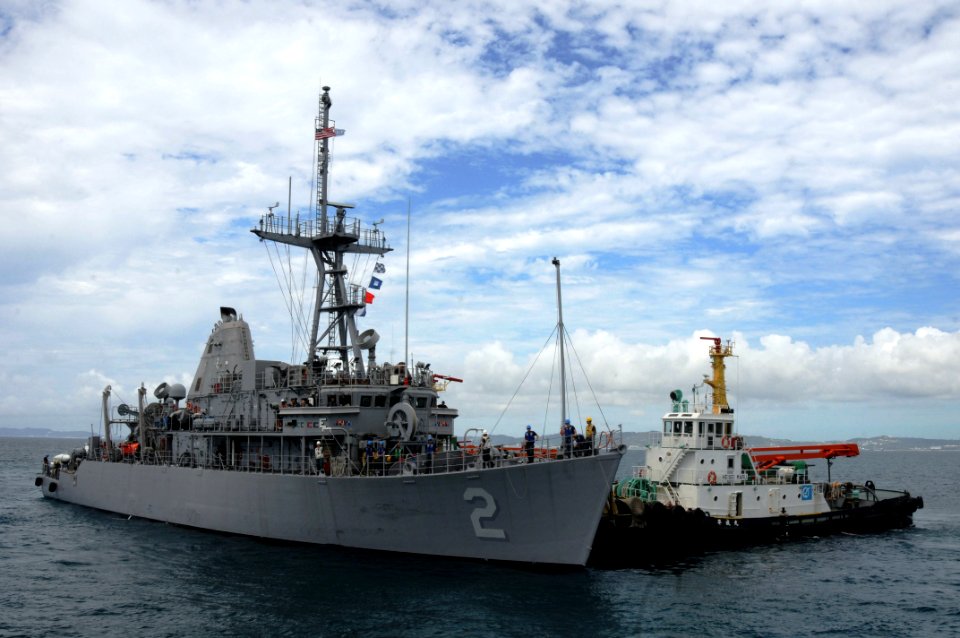 US Navy 110815-N-SP676-106 A tug boat pulls the mine countermeasures ship USS Defender (MCM 2) into White Beach Naval Facility, Okinawa, during a d