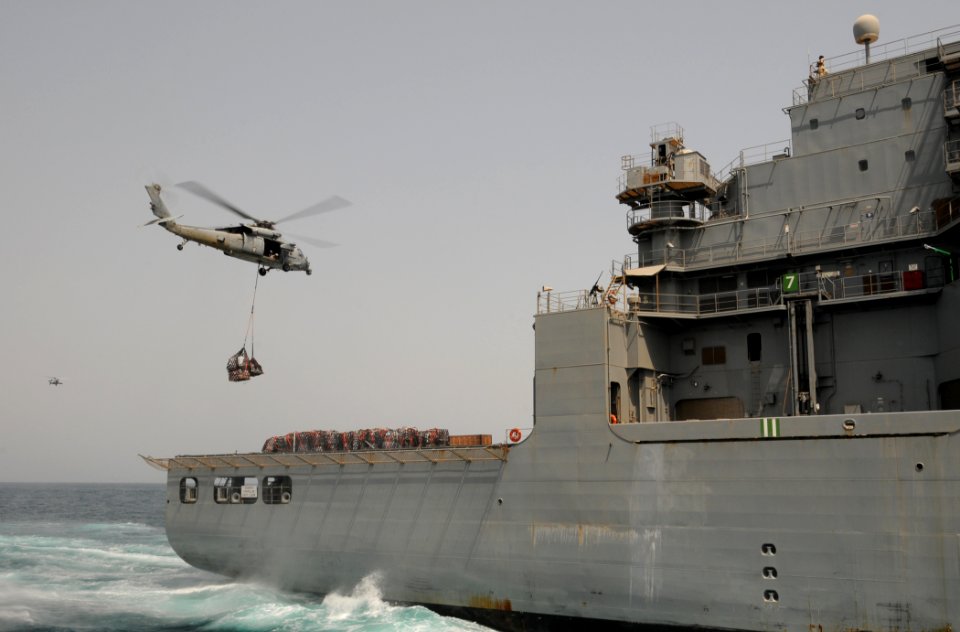 US Navy 110812-N-XQ375-446 An SH-60 Sea Hawk helicopter transfers pallets of stores from the Military Sealift Command dry cargo and ammunition ship