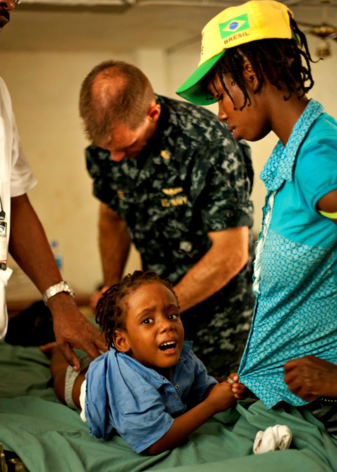 US Navy 110818-N-NY820-537 Lt. Cmdr. Timothy Mickel examines a patient at the Killick Haitian Coast Guard Base surgical screening site during Conti