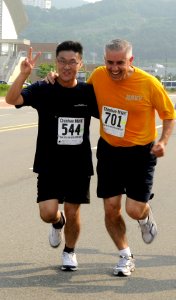 US Navy 110815-N-XG305-722 Capt. Sal Aguilera, the U.S. 7th Fleet Chaplain, right, and Republic of Korea Petty Officer Park reach the finish line d