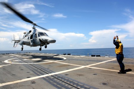 US Navy 110817-N-ZI300-113 Boatswain's Mate 3rd Class James Holmes, a landing safety enlisted, directs an Ecuadorian navy Bell 230 helicopter to ta