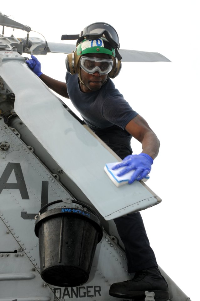 US Navy 110815-N-DU438-040 Aviation Machinist's Mate 2nd Class Othello Adou, assigned to Helicopter Maritime Strike Squadron (HSM) 70, cleans a rot