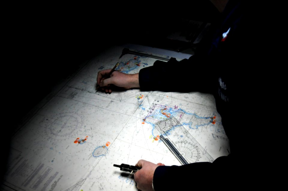 US Navy 110818-N-YM590-011 Operations Specialist 2nd Class Carl Bowman plots the position of the guided-missile cruiser USS Anzio (CG 68)