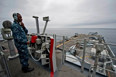 US Navy 110821-N-DX615-233 Seaman Deandre Johnson stands the forward lookout watch during flight operations aboard the amphibious assault ship USS
