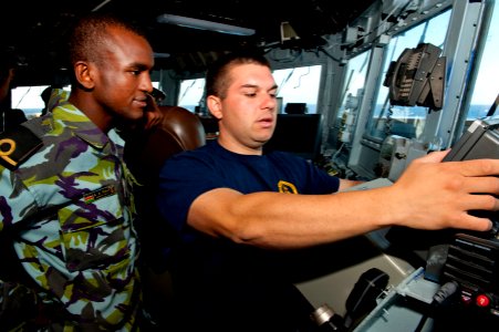 US Navy 110819-N-OV802-035 Quartermaster Seaman Kyle Seaux demonstrates for Kenyan navy 2nd Lt. A.A. Haji how to us the shipboard navigation system