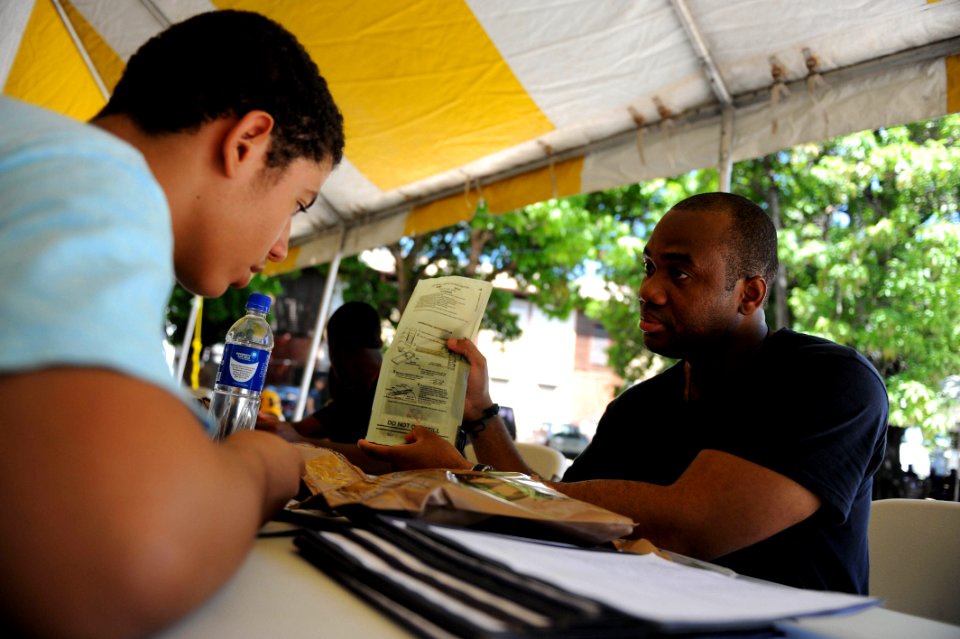 US Navy 110818-F-ET173-013 Hospital Corpsman 2nd Class Ewaldson Francois, a Haitian-American, shows a Haitian translator how to prepare a Meal-Read photo