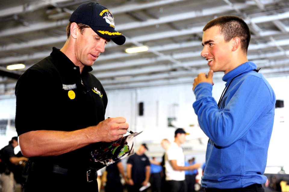 US Navy 110816-N-AU622-065 NASCAR driver Carl Edwards signs an autograph for Airman Kyle O' Brian in the hanger bay of aircraft carrier USS Dwight