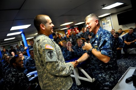 US Navy 110819-N-YR391-007 MCPON Rick D. West gives his challenge coin to OS2 Rolando Albarracin