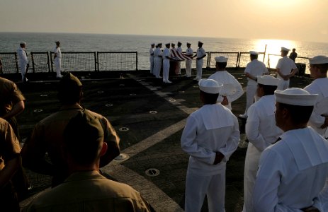 US Navy 110822-N-AG285-321 Sailors and Marines stand at parade rest during a burial at sea ceremony for three U.S. Navy veterans aboard the amphibi photo