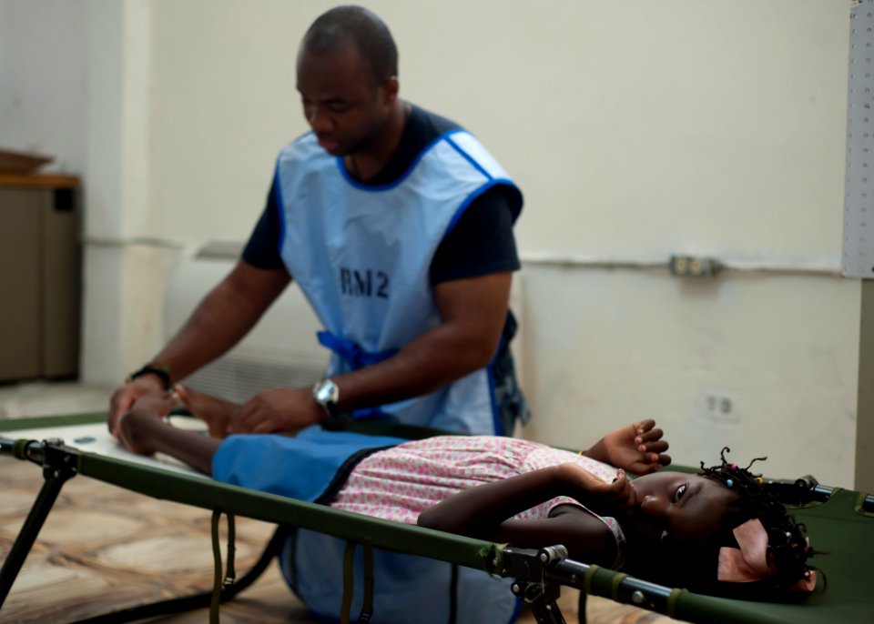 US Navy 110818-N-NY820-290 Hospital Corpsman 2nd Class Ewaldson Francois, a Haitian-American, prepares a patient for an X-ray at the Killick Haitia photo