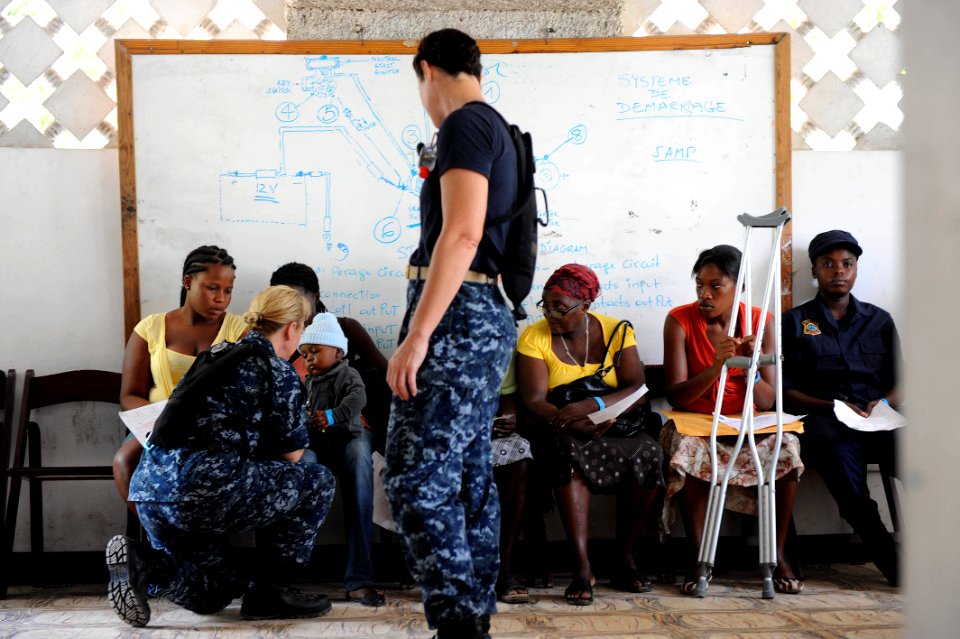 US Navy 110825-F-ET173-189 Lt. Cmdr. Sue Passalacqua, a nurse from Seattle, speaks with a pediatric patient at the Killick Coast Guard Base medica