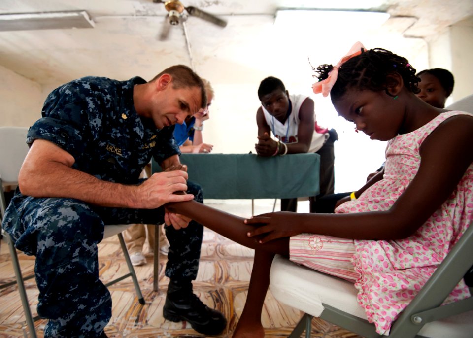 US Navy 110818-N-NY820-260 Lt. Cmdr. Timothy Mickel examines a patient at the Killick Haitian Coast Guard Base surgical screening site during Conti