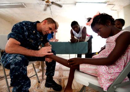 US Navy 110818-N-NY820-260 Lt. Cmdr. Timothy Mickel examines a patient at the Killick Haitian Coast Guard Base surgical screening site during Conti