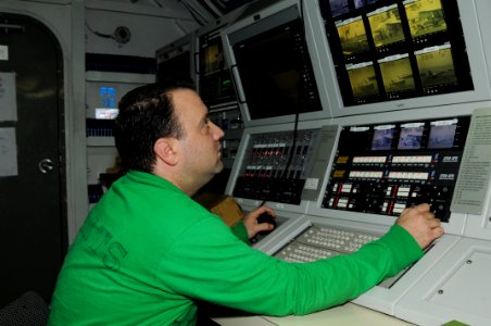 US Navy 110821-N-TU894-001 Interior Communications Electrician 3rd Class Jeremy A. Heinz operates the Integrated Launch and Recovery Television Sys