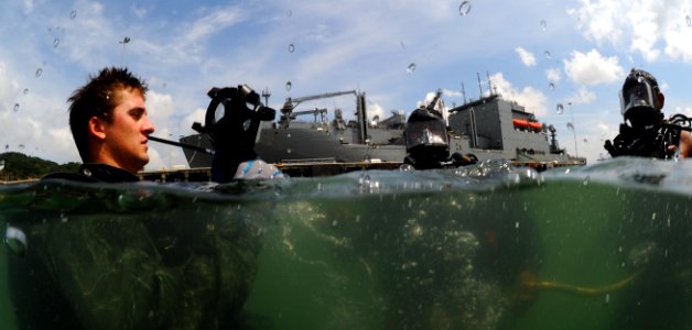 US Navy 110818-N-XD935-107 Navy Diver 2nd Class Ryan Arnold, left, assigned to Company 2-3 of Mobile Diving and Salvage Unit (MDSU) 2, prepares his