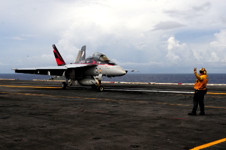 US Navy 110824-N-UO379-471 Aviation Boatswain's Mate (Handling) 1st Class Robin Calcaterra directs an F-A-18F Super Hornet assigned to the Black Kn