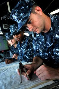 US Navy 110817-N-SF508-015 Quartermaster 2nd Class David Belt, from Monterrey, Calif., conducts chart plotting training on the bridge of the Arleig