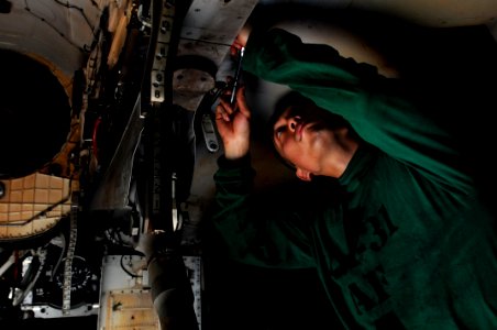 US Navy 110820-N-XE109-304 Aviation Structural Mechanic 2nd Class Jung Lee performs maintenance on the tailhook of an F-A-18E Super Hornet assigned