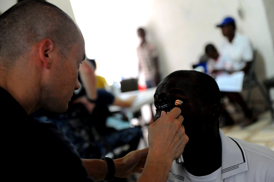 US Navy 110825-F-ET173-274 Lt. Cmdr. Robert Franks, an optometrist from Vacaville, Calif., checks a patient's eyes at the Killick Coast Guard Base