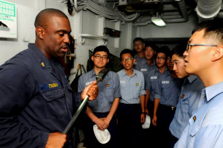 US Navy 110818-N-XG305-553 Chief Damage Controlman Ernest Thomas explains how to use a halogen tool for overhauling a fire to Republic of Korea sai