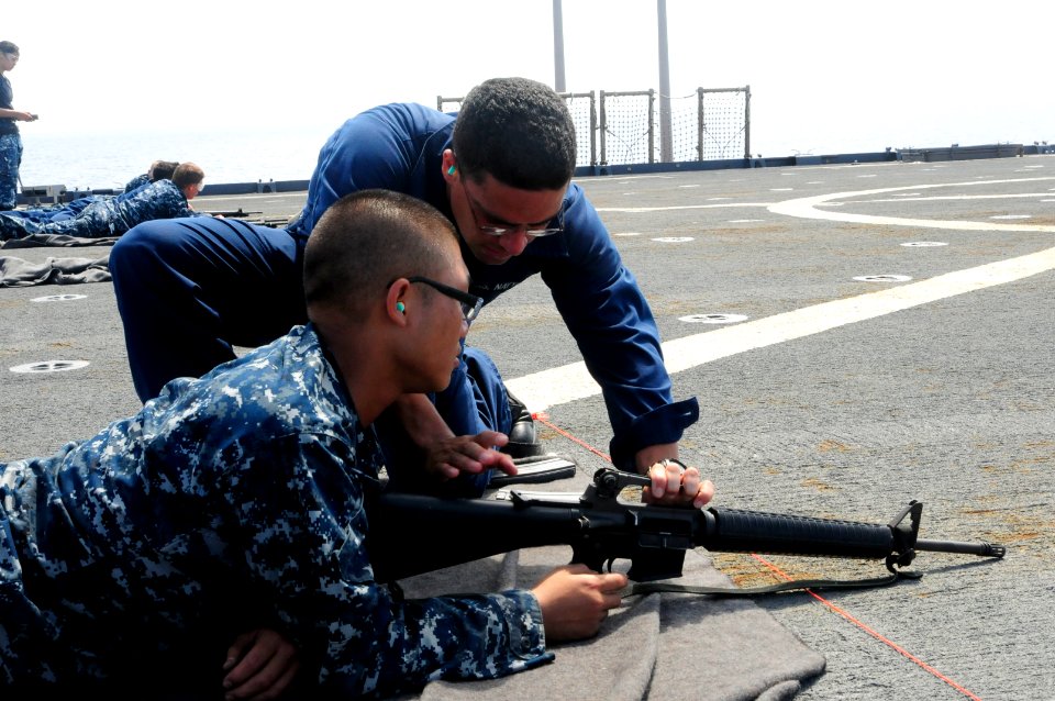 US Navy 110824-N-WV964-015 Boatswain's Mate 2nd Class Dennis Castro explains gun safety to Boatswain's Mate Seaman Guozhi Lei before a live-fire ex