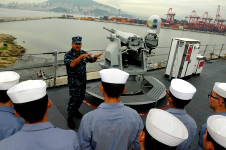 US Navy 110819-N-XG305-208 Gunner's Mate 1st Class Eduardo Soto explains the capabilities of the MK 38 25mm machine gun to Republic of Korea sailor