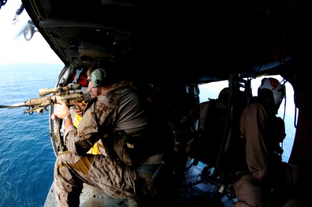 US Navy 110822-N-XE109-945 A Navy SEAL fires an MK-11 sniper rifle from an MH-60S Sea Hawk helicopter