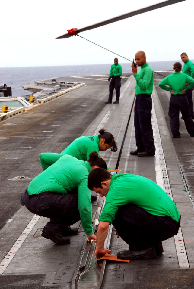 US Navy 110826-N-KF029-037 Aviation boatswain's mates clean a catapult on the flight deck aboard the aircraft carrier USS Ronald Reagan (CVN 76)