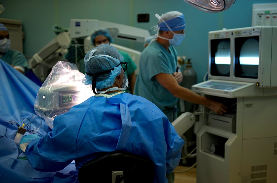 US Navy 110825-N-EP471-072 Lt. Cmdr. Timothy Mickel reviews an X-Ray of his patient's hand as he performs finger surgery