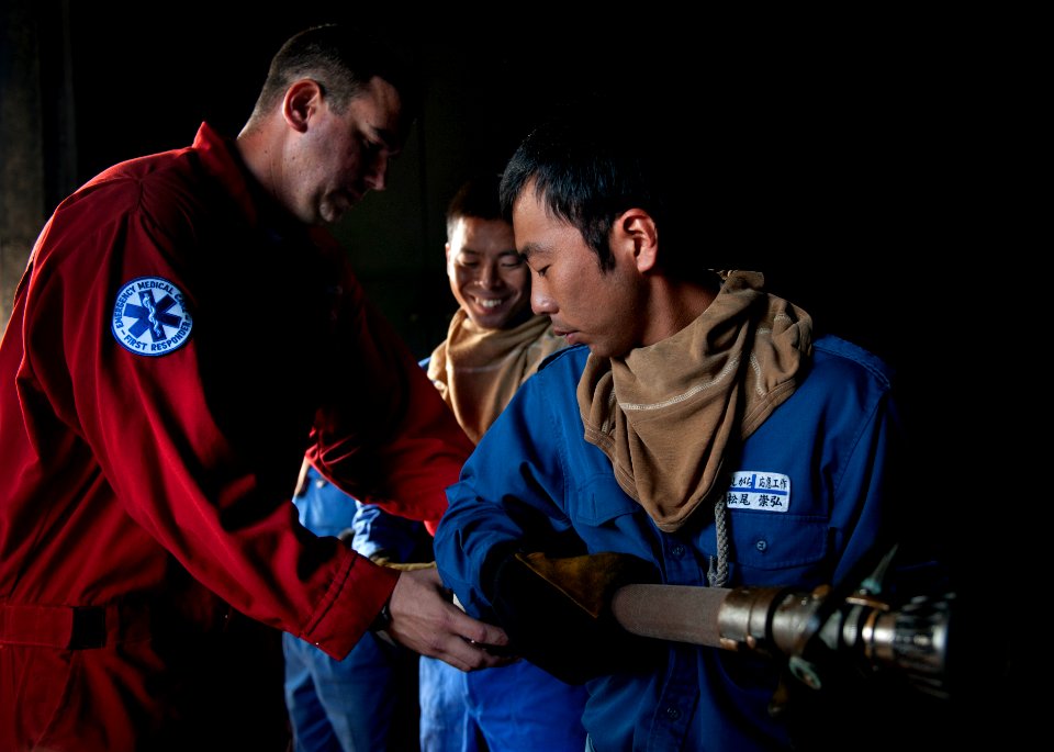 US Navy 110824-N-DR144-591 Damage Controlman 2nd Class Nathan Almada teaches hose handling techniques to Japan Maritime Self-Defense Force sailors