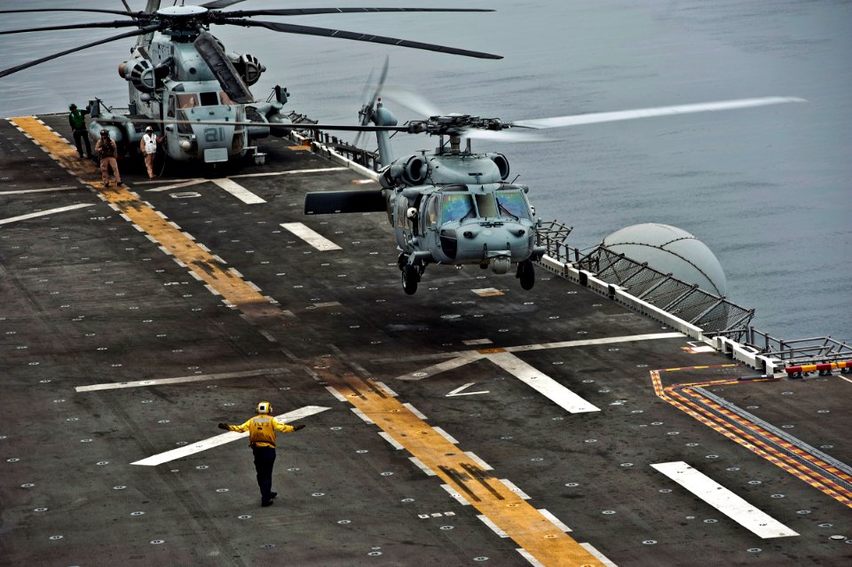 US Navy 110821-N-DX615-058 An MH-60S Sea Hawk helicopter assigned to the Wild Cards of Helicopter Sea Combat Squadron (HSC) 23 lands aboard the amp