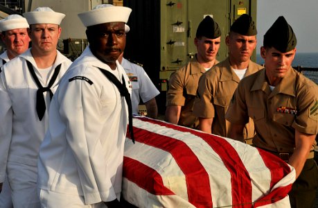 US Navy 110822-N-AG285-281 Sailors and Marines carry a casket during a burial at sea ceremony for three U.S. Navy veterans aboard the amphibious do photo