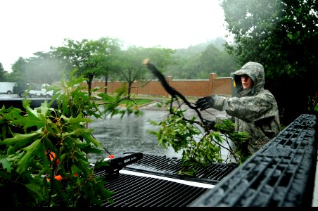 US Navy 110827-F-ZE674-122 Senior Airman Joshua Garner cleans up tree branches that were knocked loose during heavy rains and winds from Hurricane