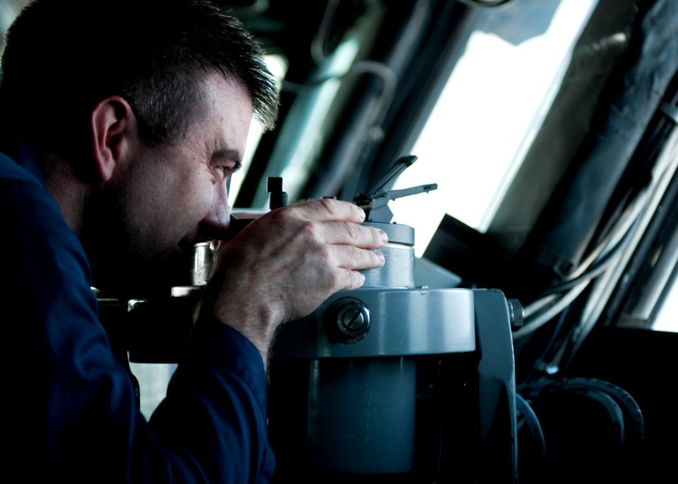 US Navy 110825-N-PM781-001 Lt. Cmdr. Timothy Reiswig, the navigator aboard the amphibious assault ship USS Wasp (LHD 1), uses a gyrocompass as the