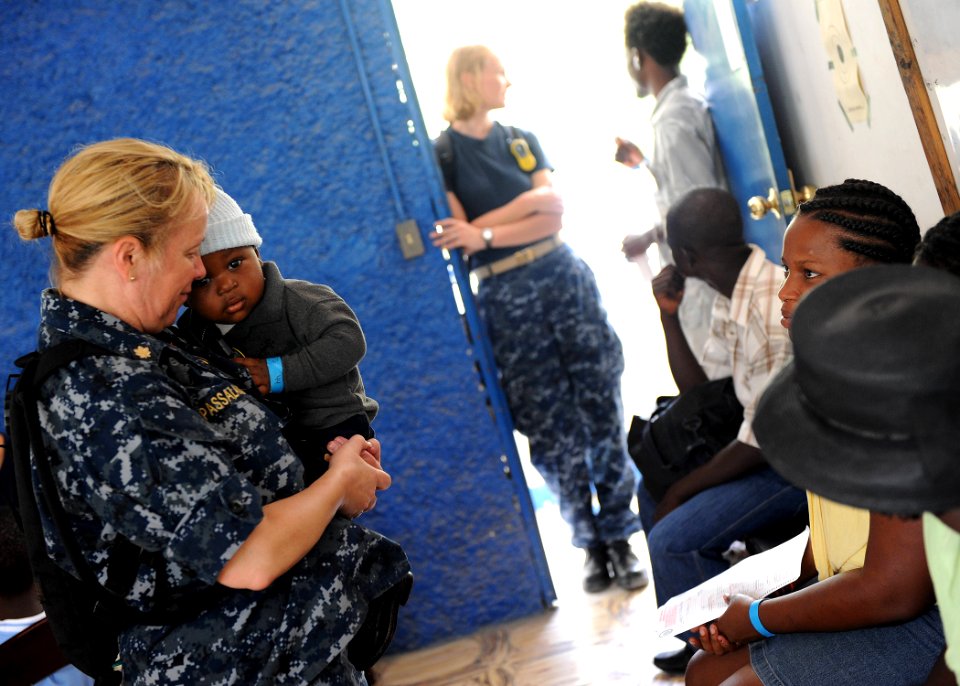 US Navy 110825-F-ET173-199 Lt. Cmdr. Sue Passalacqua, a nurse from Seattle, holds a pediatric patient at the Killick Coast Guard Base medical site