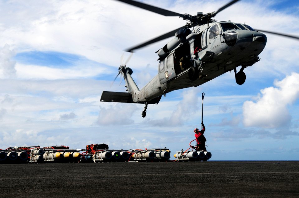 US Navy 110828-N-SB672-009 An MH-60S Sea Hawk helicopter prepares to lift a pallet of ordnance from USS Ronald Reagan (CVN 76) during an ordnance h