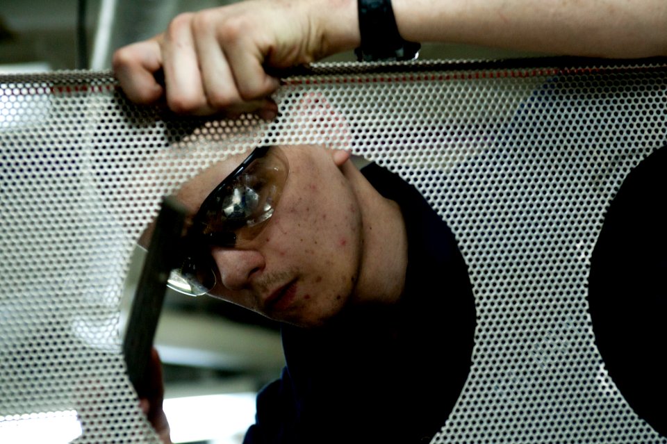 US Navy 110829-N-BT887-071 Hull Maintenance Technician Seaman Mitch Myrstal files the edge of a fabricated part aboard USS John C. Stennis (CVN 74)