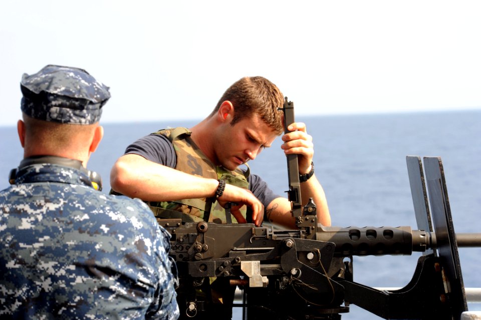 US Navy 110829-N-AU622-051 Gunner's Mate 2nd Class James Autry checks the condition of a .50 caliber machine gun before target practice