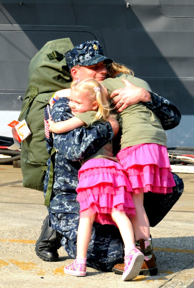 US Navy 110829-N-XG305-376 Chief Intelligence Specialist Marc De St. Aubin hugs his daughters after USS Blue Ridge (LCC 19) arrives at Commander, F