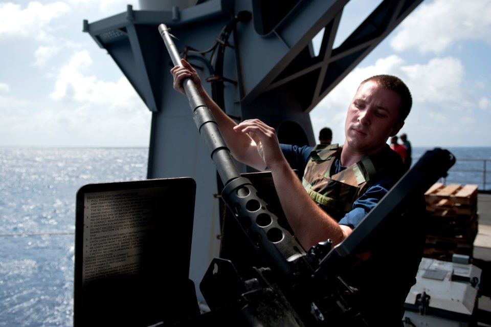 US Navy 110831-N-BT887-041 Aviation Ordnanceman Airman Scott Segel, from Antioch, Ill., changes the barrel of a .50-caliber machine gun aboard the