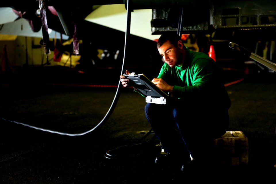 US Navy 110829-N-BT887-007 Aviation Electronics Technician Airman Matt Anderson checks specifications during maintenance on an F-A-18F Super Hornet