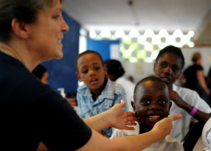 US Navy 110828-N-NY820-257 Lt. Cmdr. Ingrid Byles examines a patient at a temporary medical site at the Killick Coast Guard Base in Port-au-Prince photo