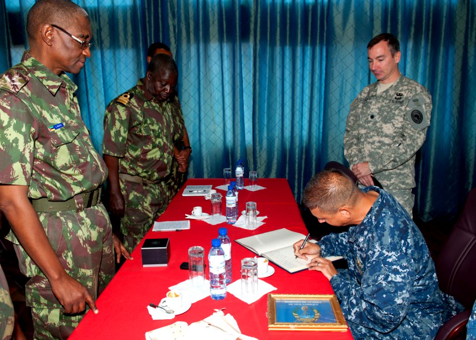 US Navy 110827-N-OV802-023 Cmdr. Angel Cruz signs Chief of the Mozambique navy Rear Adm. L.L. Menete's guest book during an office call