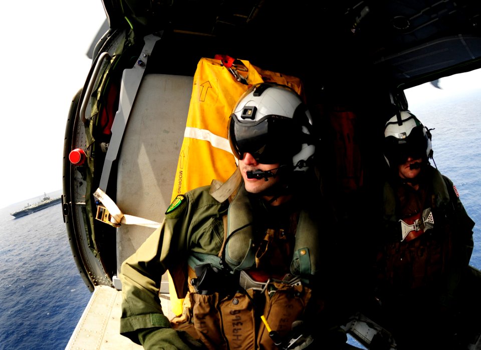 US Navy 110830-N-ZZ999-187 Sailors look on from the cabin of an MH-60S Sea Hawk helicopter