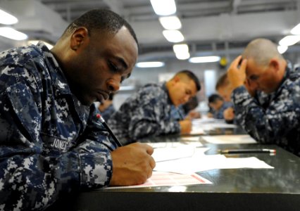 US Navy 110901-N-KD852-038 Electrician's Mate 2nd Class Carl Jones takes the E-6 advancement exam on the mess decks aboard the amphibious assault s photo