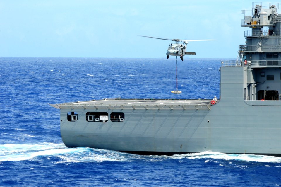 US Navy 110828-N-SB672-267 An MH-60S Sea Hawk helicopter prepares to drop a pallet of ordnance from USS Ronald Reagan (CVN 76) onto USNS Charles Dr