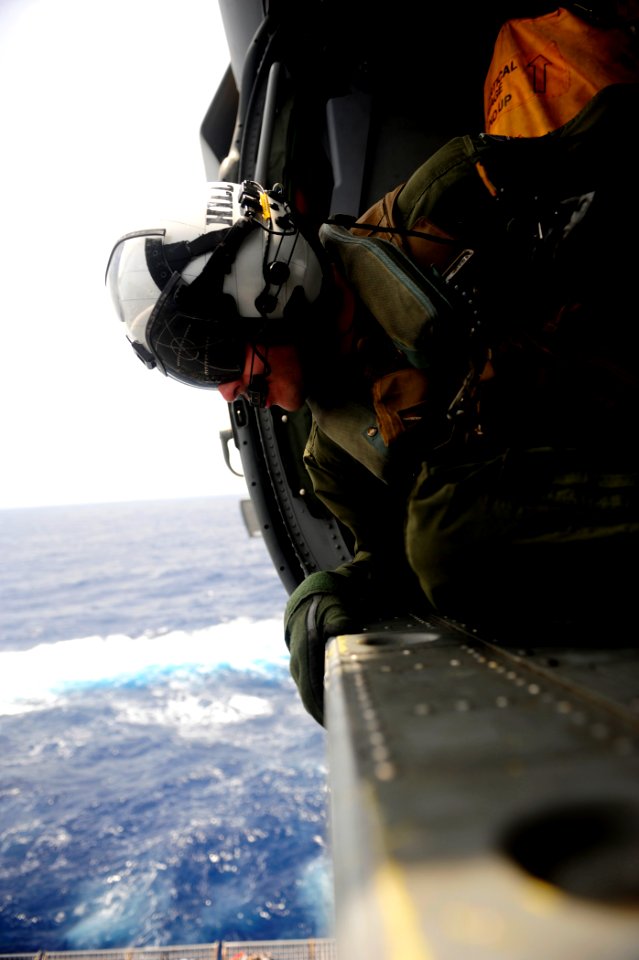 US Navy 110830-N-ZZ999-279 Naval Air Crewman 2nd Class Aaron Hill, from Columbus, Ohio, looks out the cabin of an MH-60S Sea Hawk helicopter