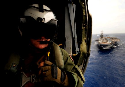 US Navy 110830-N-ZZ999-520 Senior Chief Naval Air Crewman Todd Yates, from Granger, Ind., looks out the cabin of an MH-60S Sea Hawk helicopter